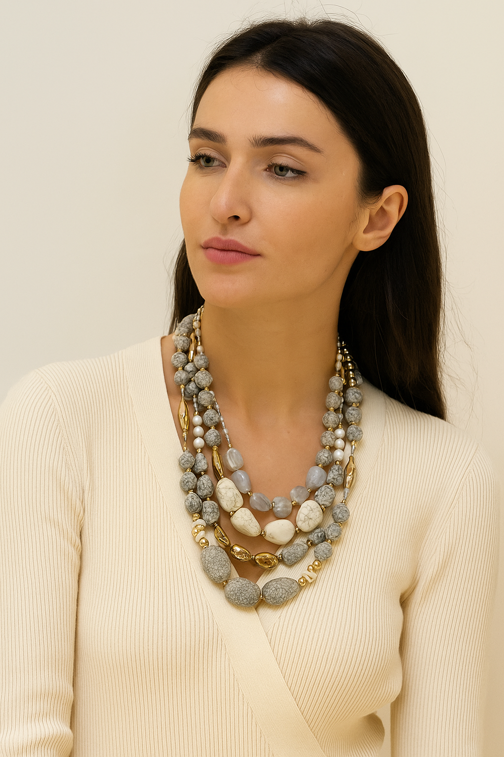 Multi-strand layered necklace featuring textured cream and gray beads with golden accents.